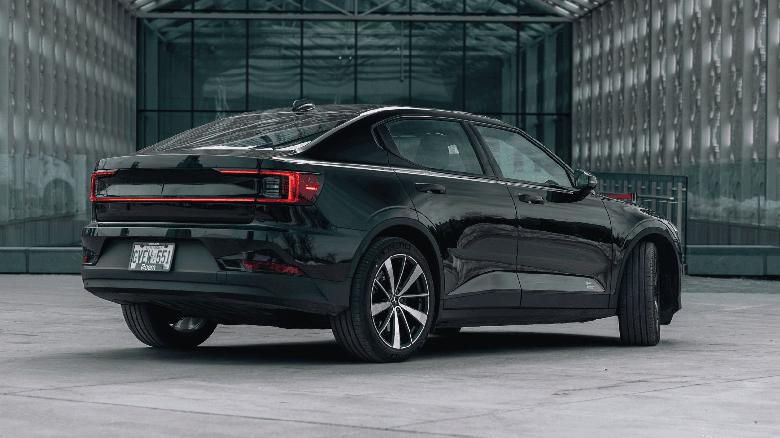 Black Polestar electric sedan in an urban plaza